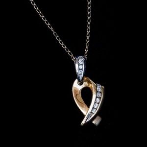 Dainty 14 Karat gold diamond ribbon pendant.